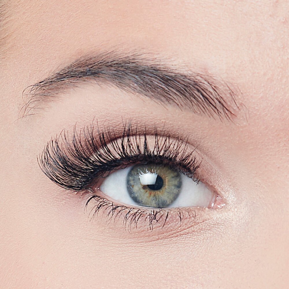 Detailed close-up of a human eye showcasing long eyelashes and a vibrant iris, highlighting eye beauty and makeup.