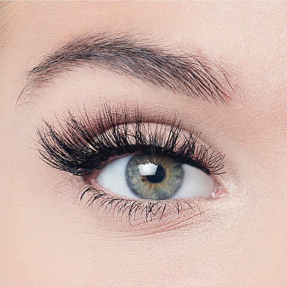 Close-up view of a human eye showcasing long, voluminous eyelashes and a vibrant iris, highlighting beauty and eye makeup.