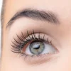 Close-up image of a human eye showcasing long, voluminous eyelashes and a bright blue iris, highlighting eye beauty and makeup.