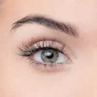 Close-up image of a woman's eye showcasing long eyelashes and a striking iris color, ideal for beauty and cosmetic products.