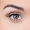 Close-up image of a human eye showcasing natural beauty, with detailed eyelashes and a striking iris color.