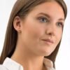 Close-up of a woman wearing elegant stud earrings, showcasing a simple and classic jewelry design suitable for various occasions.