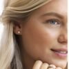 Close-up of a woman wearing elegant diamond stud earrings, showcasing a classic jewelry design that enhances beauty and style.