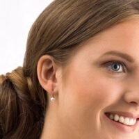 Close-up of a woman wearing elegant silver pearl earrings, showcasing a classic design that enhances any outfit with a touch of sophistication.