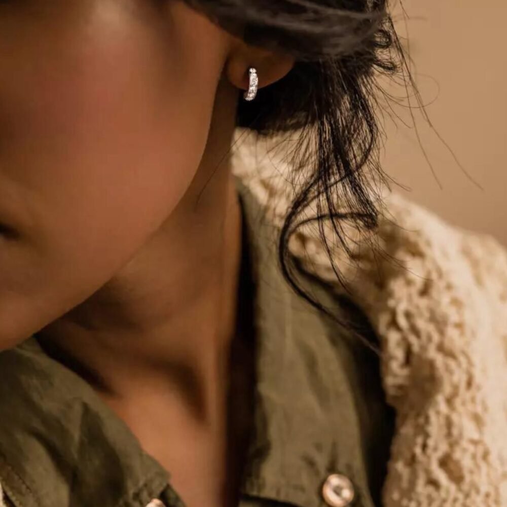 Close-up of elegant hoop earrings worn by a model, showcasing a stylish design with sparkling accents, perfect for any occasion.