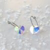 Heart-shaped crystal earrings with a shimmering finish, featuring a silver hoop design and colorful reflections, ideal for jewelry collections.