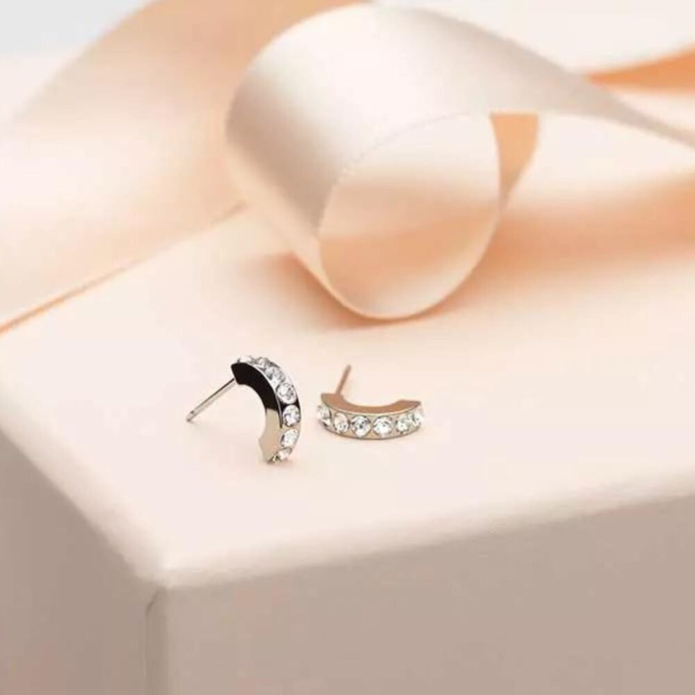 Elegant gold and crystal crescent earrings featuring a sleek design, perfect for adding a touch of glamour to any outfit.