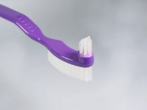 Purple toothbrush featuring soft bristles designed for gentle cleaning and oral hygiene, ideal for daily use and effective plaque removal.