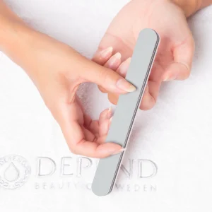 Depend nail file being used on natural nails for shaping and smoothing, ideal for manicure routines.