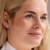 Close-up of a woman wearing crescent moon earrings and a nose ring, showcasing modern jewelry design and style.