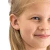 A young girl with blonde hair wearing pink heart-shaped earrings, showcasing a cheerful expression and blue eyes.